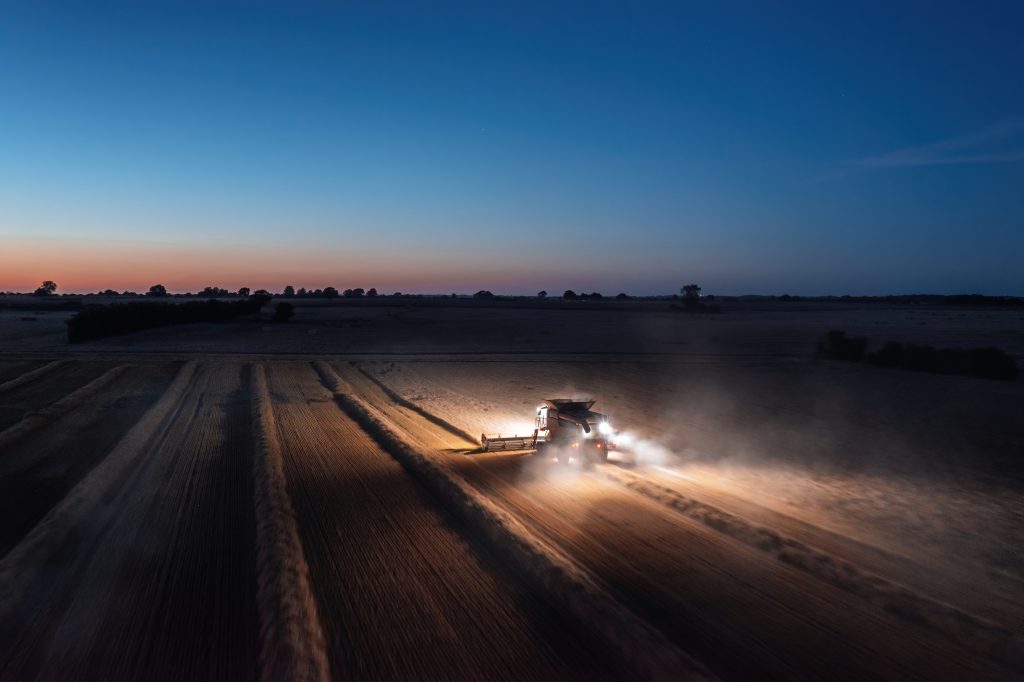 Harvesting at dusk Aerial view of combine harvester at night